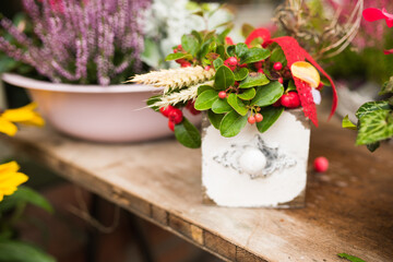 Preetz, Beautiful autumn floral arrangement with pink cyclamens, white chrysanthemums, ornamental cabbage, and ivy, decorated with a delicate lace heart, creating a cozy and romantic seasonal display.