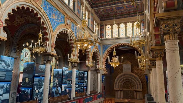The opulent Neo-Moorish interior of the Spanish Synagogue in Prague, Czech Republic. Exquisite geometric patterns, vibrant colors, and elaborate gold ornamentation showcase 