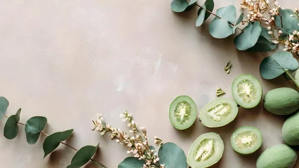 Fototapete Badezimmer Green feijoa halves on a beige background, framed by eucalyptus leaves and pale flowers. Concept Botanical still life, Feijoa halves, Eucalyptus leaves, Pale flowers, Beige background  © Anastasiia