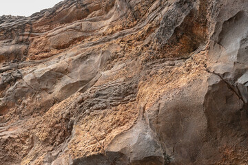 Roughly surface of sand stone formation at mountain cliff in arid desert area, background and texture in nature environment.