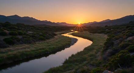 Sunset over a winding river with mountains and green landscape