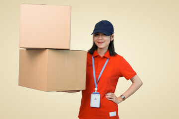 A delivery worker in a red shirt and navy cap holds and lift a large package cardboard box, looking confidence