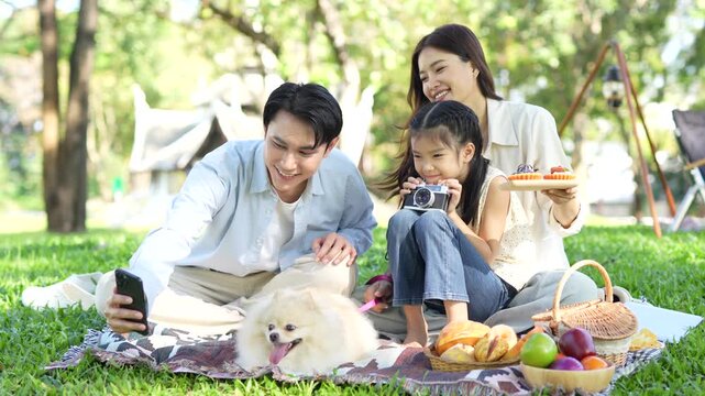 Happy family with children in the park taking selfies with smartphones