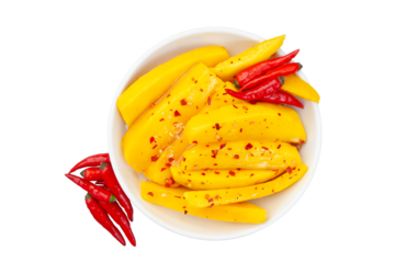 Bowl of sliced mangoes with red chili peppers on top