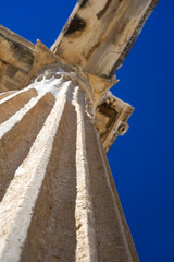An Architectural Marvel: Capturing the Majestic Details of an Ancient Column Set Against a Clear Blue Sky