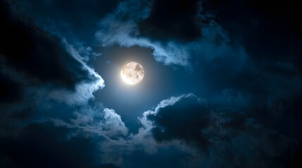 Fototapeta premium Bright moon shines through dark, dramatic clouds in the night sky.