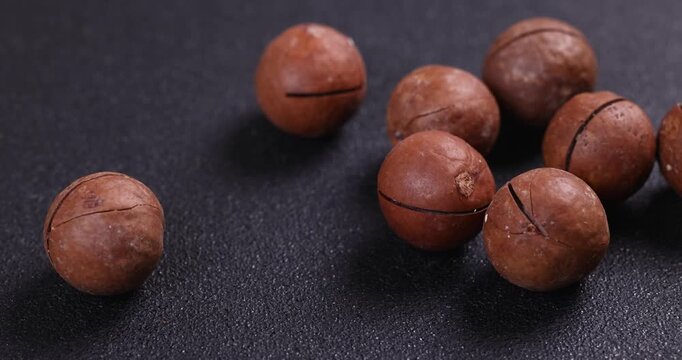 Macadamia nuts slowly rolling on table