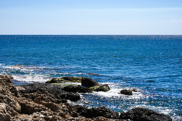 Serene Coastal View Featuring Rocky Outcrops and Clear Blue Waters Under a Bright Sky