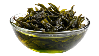 A clear glass bowl holds dark green, leafy greens soaking in a verdant, translucent liquid