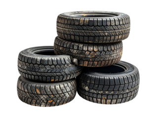 A pile of used tires, stacked in a slightly haphazard arrangement on a black background