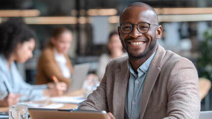 Obraz premium Smiling black manager using digital tablet during office meeting