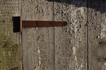 old padlock. Closeup view of an old padlock covered in rust, attached to a cracked wooden door. It represents themes of security, the passage of time, decay, and vintage aesthetics. the door is locked