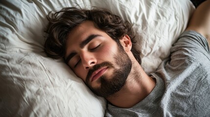 A man sleeping on a pillow with a blanket.