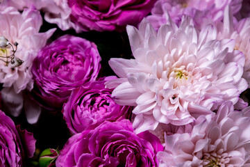 Fototapeta premium Beautiful arrangement of pink and purple flowers featuring roses and chrysanthemums in a lush bouquet in a natural setting