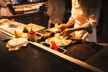 Chef baker making pizza at the kitchen.