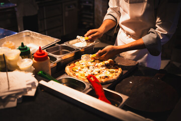 Chef baker making pizza at the kitchen.