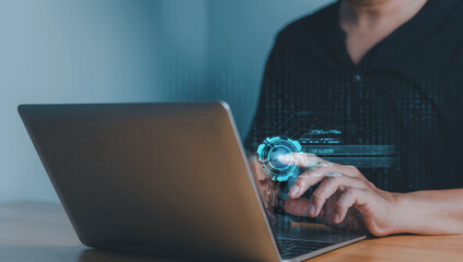 Person working on a laptop with a glowing holographic user interface, representing cybersecurity, technology innovation, data analysis, and digital transformation.