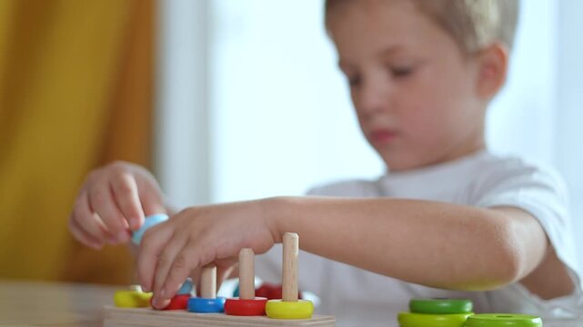Child playing puzzle indoors. Focused boy solving colorful puzzle for education. Educational puzzle helps child cognitive development. Fun learning activity for child through puzzle education.