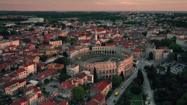 Flying above historic city of Pula , historic Roman amphitheatre of Pula aerial view, tourism in Croatia
