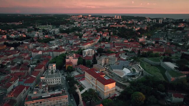 Flying above historic city of Pula , historic Roman amphitheatre of Pula aerial view, tourism in Croatia