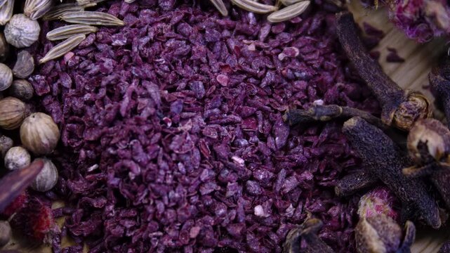 Vibrant purple Sumac: Detailed macro shot of Rhus coriaria spice with a rich purple granular texture.