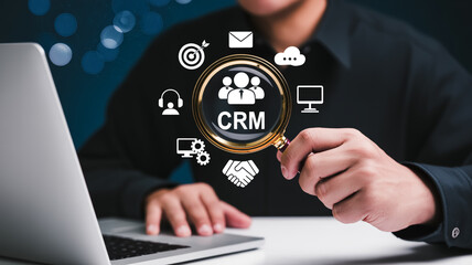 A professional business concept illustration of a hand holding digital CRM dashboard interface with icons for data analysis, marketing, communication, and customer management.