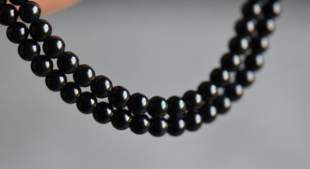 Obraz premium Elegant black pearl necklace arrangement shimmering with luxurious depth, perfect for sophisticated style and timeless fashion