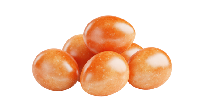 Pile of smooth, orange-colored candies with a glossy finish and small speckles, isolated on black