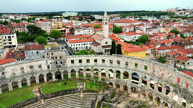 Flying above historic city of Pula , historic Roman amphitheatre of Pula aerial view, tourism in Croatia