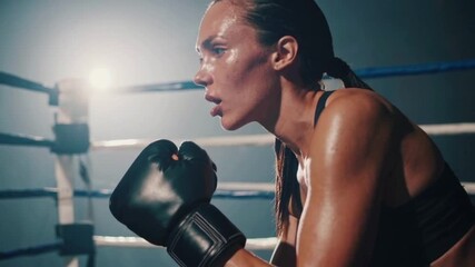 Young muscular woman boxer in gloves performs fitness workout at the gym - Powered by Adobe
