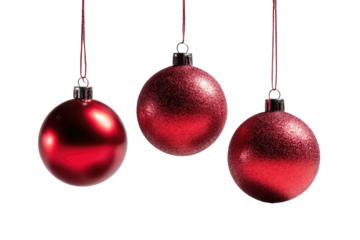 Three vibrant red spherical ornaments, suspended by fine cords, against a stark, deep black backdrop