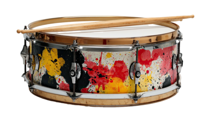 A snare drum, colorfully adorned with paint splatters, rests with drumsticks on top