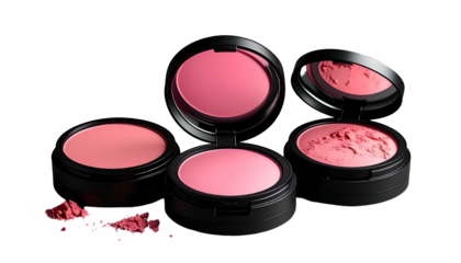 Three open compacts of pink blush, scattered powder on black, lit from above