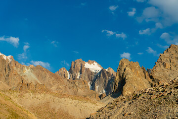 Jagged Korona peak dominates the skyline. Ala-Archa Park, Ratsek camp. surrounded by rugged cliffs, snow patches. Offering challenging routes for trekking, alpine climbing, mountaineering