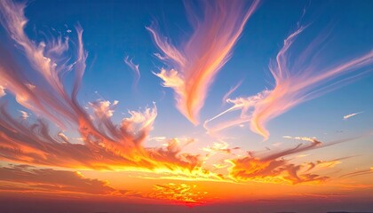 Wispy Cirrus Clouds Painted Orange and Pink by a Fiery Sunset Over a Distant Horizon Under a Clear Blue Sky