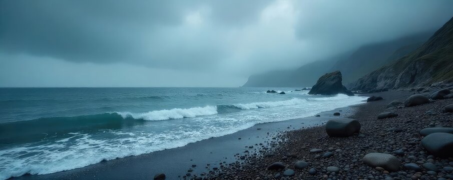 Moody overcast sky hangs low over a rocky, mist-shrouded shoreline, waves gently lapping against the grey stones  Perfect for atmospheric and dramatic imagery ,  scenery,  fog - Powered by Adobe
