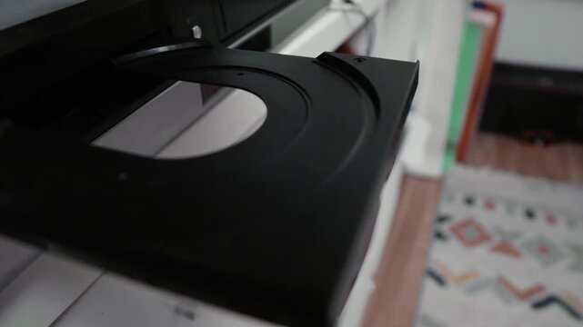 Woman puts a dvd disc into media player.