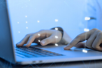 Working on a laptop with digital interface during the day in a modern office setting