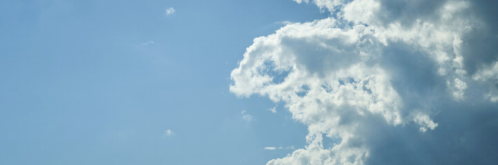 Bright blue sky with fluffy white clouds on a clear sunny day.