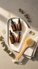 Essential oil bottles arranged on tray with towel and brush  