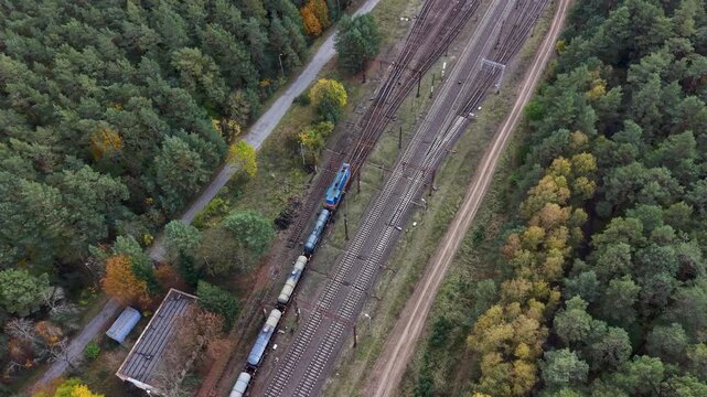 Aerial forest train railroad transportation station Poland 3. Northern Poland. Main transportation network for cargo and passengers in Europe. Trains are electric with overhead wires. Rural forest. - Powered by Adobe