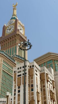 minaret of mosque, The majestic architecture of Mecca, Saudi Arabia. A minaret with intricate traditional Islamic design stands against a bright blue sky, with the modern Abraj Al Bait Clock Tower. 
