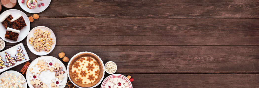 Christmas holiday cookies and desserts corner border. Top view on a dark wood banner background. Eggnog pie, an assortment of cookies, fruit cake, cupcakes and chocolate eggnog. Copy space. - Powered by Adobe
