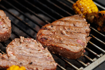 Sizzling steaks and golden corn cook over a hot grill, filling the air with delicious aromas of summer fun.