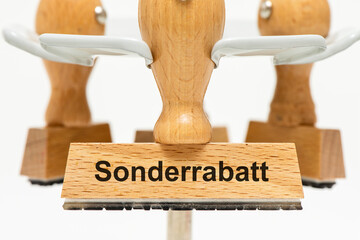 Ein Holzstempel ist beschriftet mit dem Aufdruck Sonderrabatt als Symbolbild für die Ankurbelung...