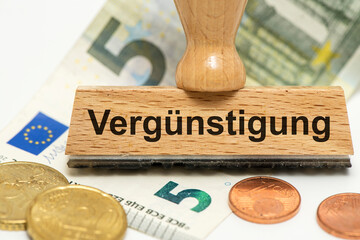 Ein Holzstempel ist beschriftet mit dem Aufdruck Vergünstigung als Symbolbild für die Ankurbelung...