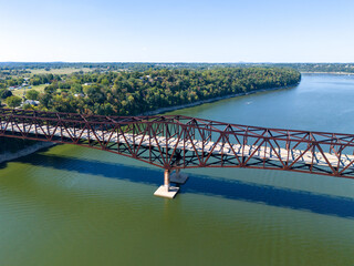 Aerial shot of rusty steel truss Bronston Bridge named The Houseboat Capital of the World Bridge spanning Cumberland River, with tree-lined banks and distant countryside