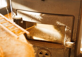 Soft light filters through, illuminating the warm aura of an old wood stove nestled in a charming...