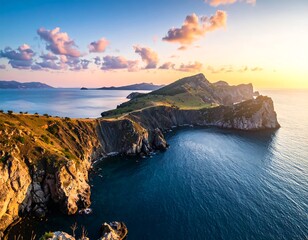 Panoramic coastal view with sunlit cliffs meeting the tranquil sea under clouds