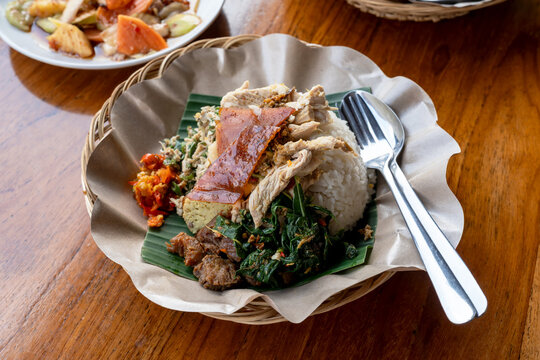 Close up of roasted pork with rice and vegetables or nasi campur babi guling Balinese food